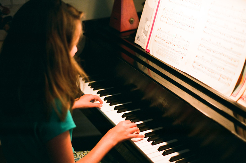 young girl playing a steinway baby grand piano
