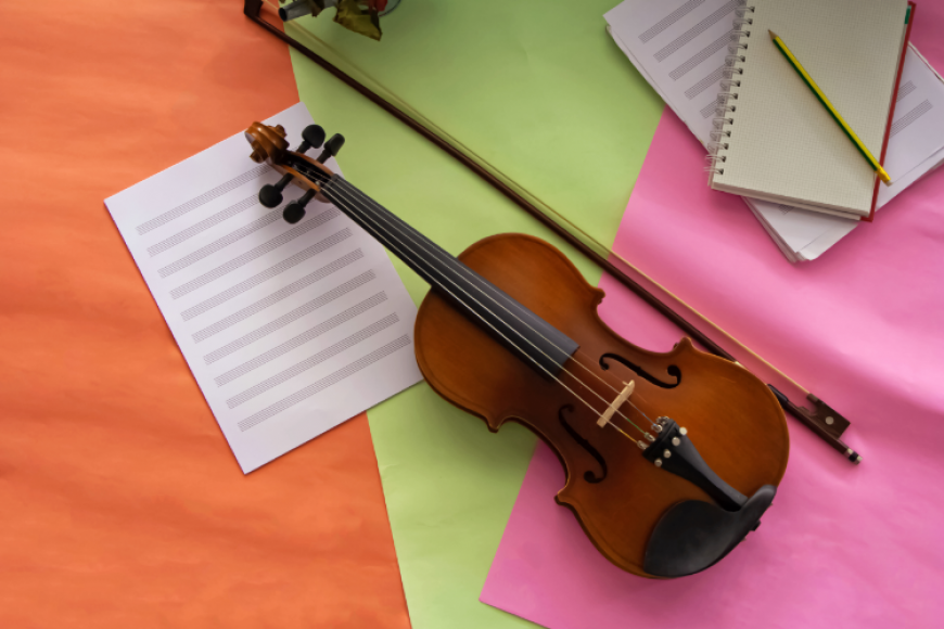 Violin and blank notebooks on a table.