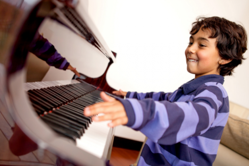Boy enjoying playing piano.