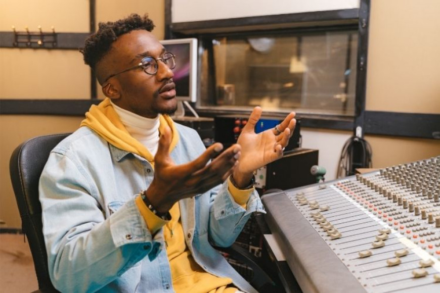 College music student at a mixing console in a recording studio.