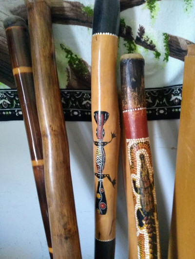 Four didgeridoos with decorative inlayed artwork.
