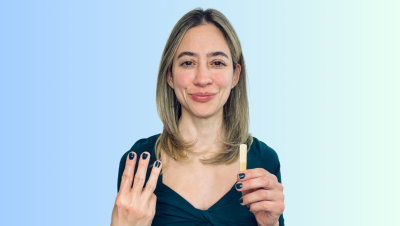 Image of Liz Ramirez holding the number 3 and a clarinet reed