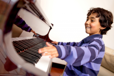 Boy enjoying playing piano.