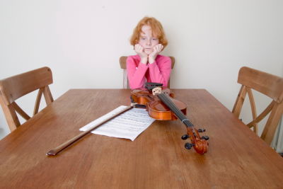 Child frustrated with practicing the violin.