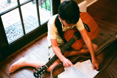 Boy with left-handed guitar and musical notation