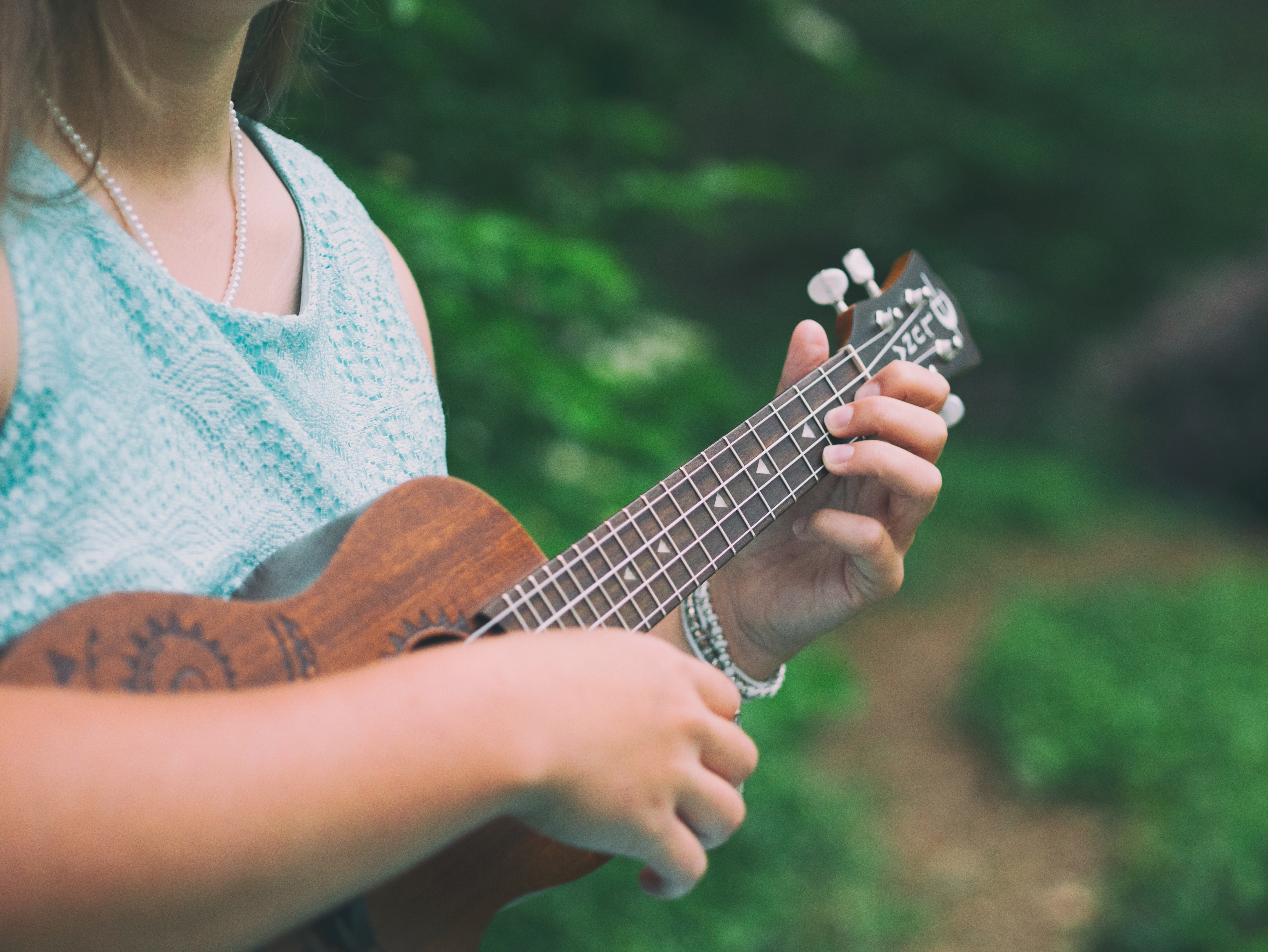 Person playing ukulele outside