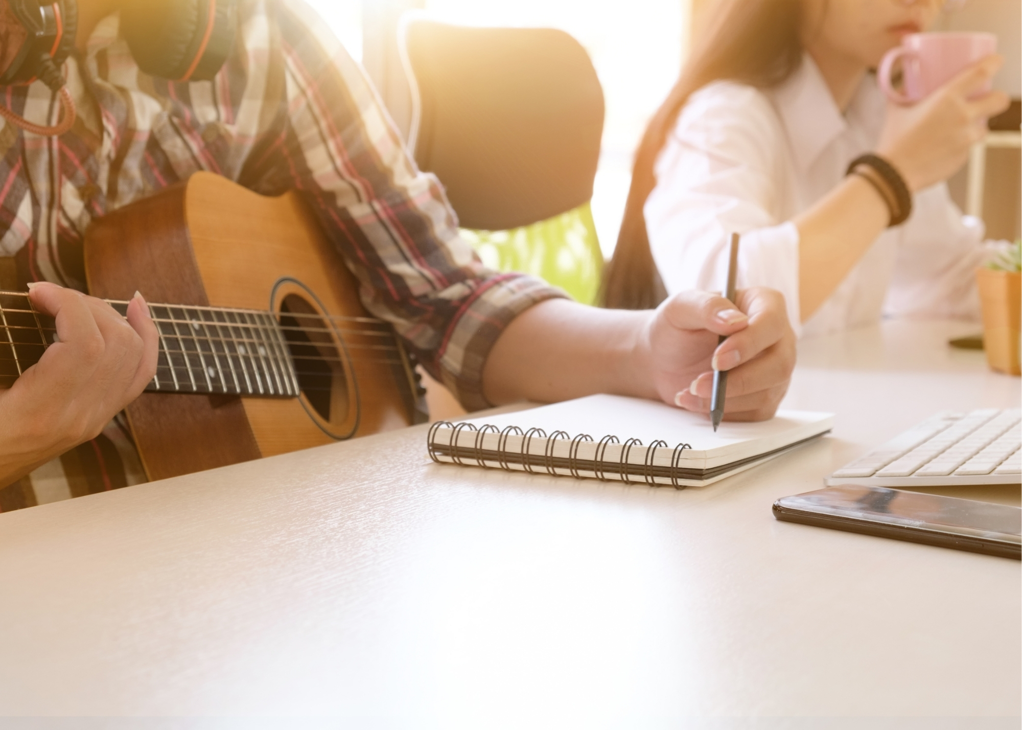 Person Playing a Guitar Writing a Song