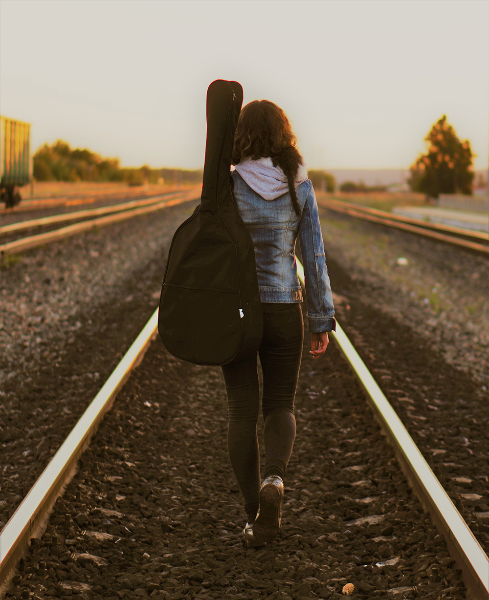 Girl walking down railroad tracks